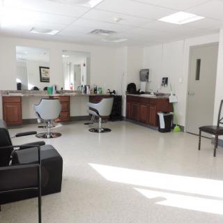 An empty salon interior with styling chairs and mirrors.
