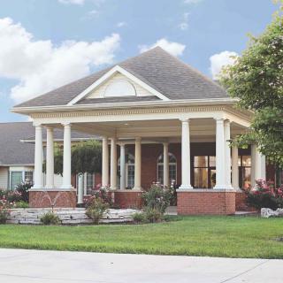 A suburban house with a large porch and white columns.
