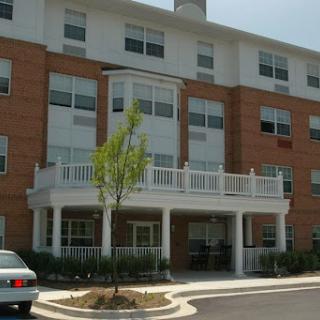 A multi-story residential building featuring a brick faade and a welcoming entrance.