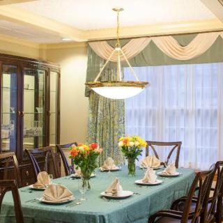 An elegantly set dining room with a chandelier and floral arrangements.