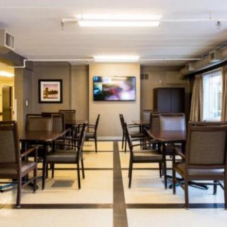 A well-lit dining room with neatly arranged tables and chairs.
