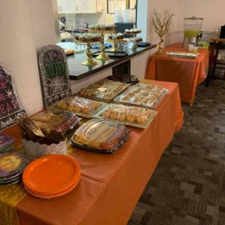A buffet table set up with a variety of food, plates, and drinks for a party.