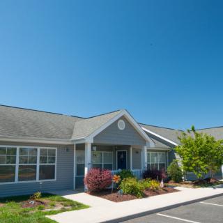 A suburban residential building with well-maintained landscaping on a sunny day.