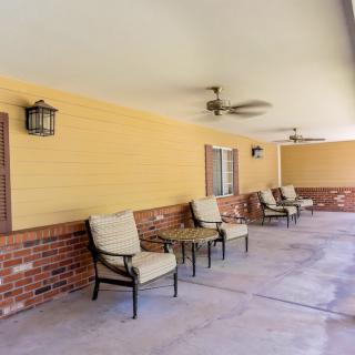 A cozy covered patio with comfortable seating and ceiling fans.