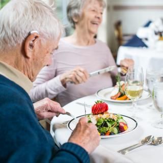 An elderly couple enjoying a meal together at a restaurant.