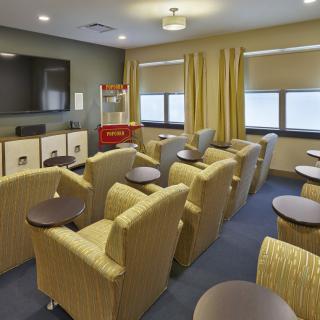 A cozy indoor movie theater room with comfortable seating and a popcorn machine.