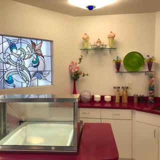 A brightly lit ice cream shop interior with a display case and colorful decorations.