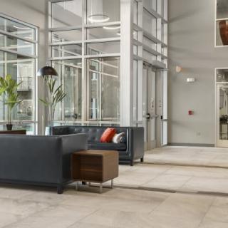 A modern office lobby with sofas and glass walls.