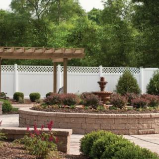 A beautifully landscaped garden featuring a pergola, fountain, and neatly arranged shrubs.