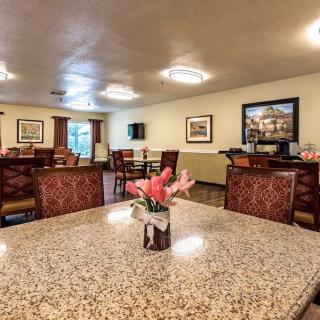 A well-lit community dining area with tables, chairs, and floral decor.