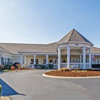 A large residential building with a prominent entrance and circular driveway.