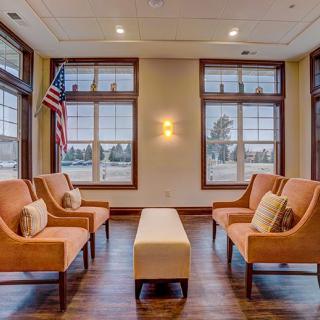 A cozy waiting area with cushioned chairs and large windows.