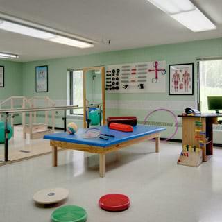 A rehabilitation room equipped with various physical therapy equipment and a therapy bed.