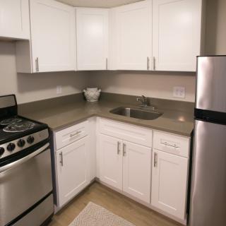A modern kitchen with white cabinets and stainless steel appliances.