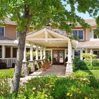A welcoming residential building with a landscaped entrance surrounded by lush greenery.