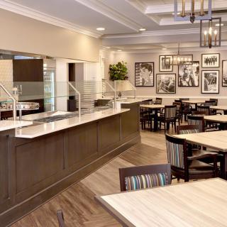 An elegant restaurant interior with a dining area and serving counter.