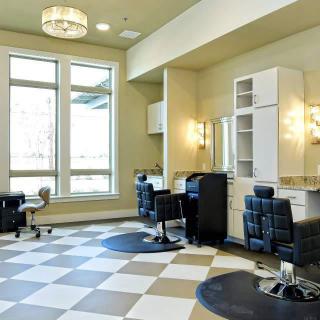 A modern and spacious salon interior with styling chairs, mirrors, and ample lighting.