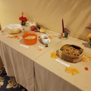 A beautifully arranged table featuring various dishes and autumn decorations.