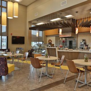 Modern cafe interior with seating and a service counter.