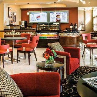 A cozy cafe interior with comfortable seating and a menu display at the counter.