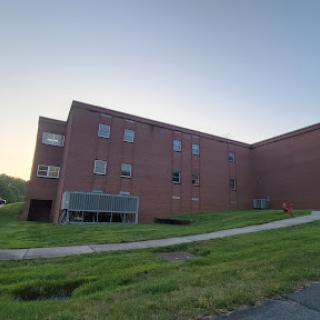 A brick building captured during sunset with lush green grass in the foreground.