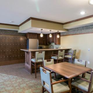 A modern kitchen and dining area featuring a wooden table, bar counter, and contemporary decor.