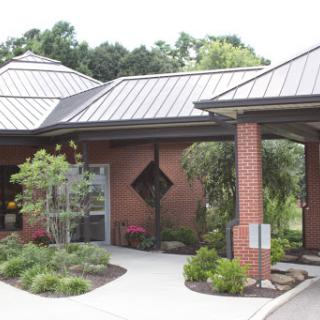 A modern building featuring a unique roof design and well-maintained landscaping.