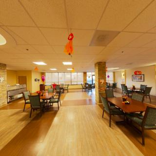 A spacious dining area with tables and chairs, featuring decorative elements and ample lighting.