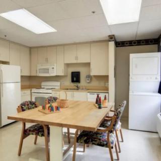 A cozy kitchen and dining area with modern appliances and a wooden table.