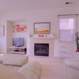 A cozy living room with a fireplace, television, and comfortable seating.