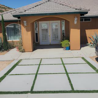 A modern house entrance with a uniquely designed driveway.