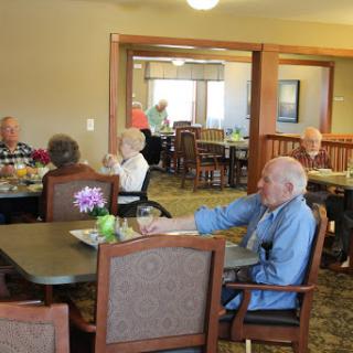 Seniors enjoying a meal together in a communal dining area.