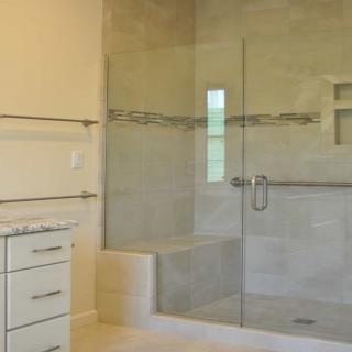 Modern bathroom with a glass-enclosed shower and tiled walls.