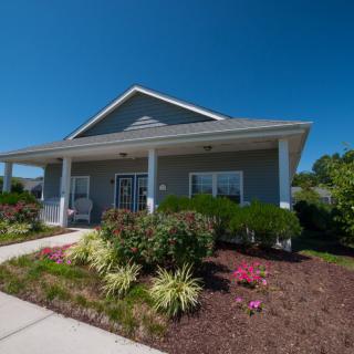 A single-story house with a well-maintained garden and a covered front porch.