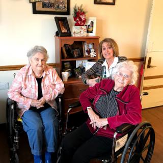 Three women enjoying time together in an assisted living setting.