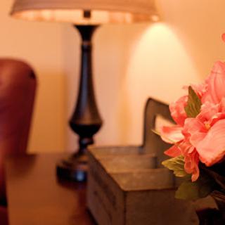 A cozy corner featuring a stylish lamp and beautiful floral arrangement.