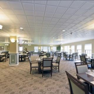 A spacious dining area with neatly arranged tables and chairs, well-lit with ample natural light.