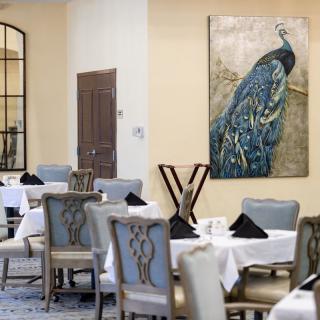 An elegant restaurant interior featuring a peacock painting on the wall.