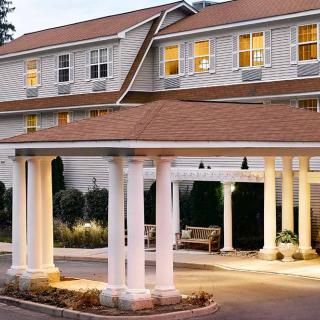 The exterior of a hotel featuring a covered entrance with columns and warm lighting.