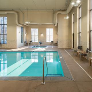 A serene indoor swimming pool featuring modern architecture and abundant natural light.