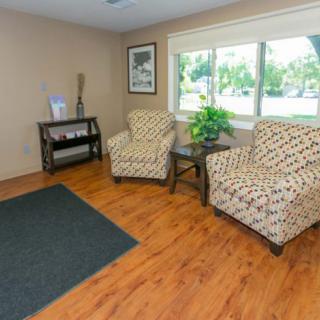 A cozy living room with patterned armchairs and a wooden floor.