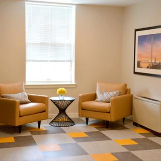 A cozy seating area featuring two stylish chairs, a small table, and a beautiful view through the window.