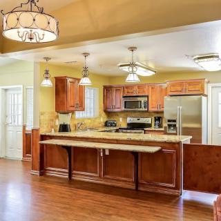 A modern kitchen with wooden cabinets, stainless steel appliances, and an island counter.