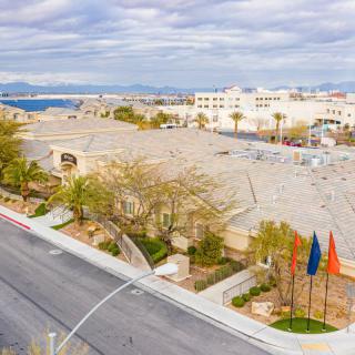 Aerial view of a suburban area with buildings, streets, and flags on a cloudy day.
