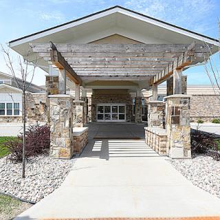 A modern building entrance with stone pillars and a covered pathway.