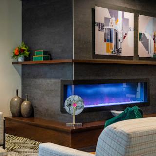 A stylish modern living room featuring a sleek fireplace and contemporary artwork.