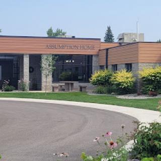 A view of a modern building surrounded by landscaped greenery.