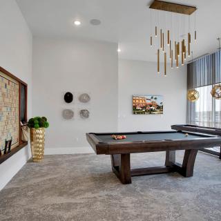 A stylish game room featuring a pool table and modern decor elements.