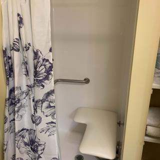 An accessible shower with a seat and grab bar.