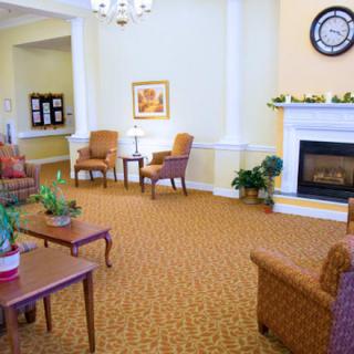 A cozy living room with comfortable seating, a fireplace, and decorative plants.